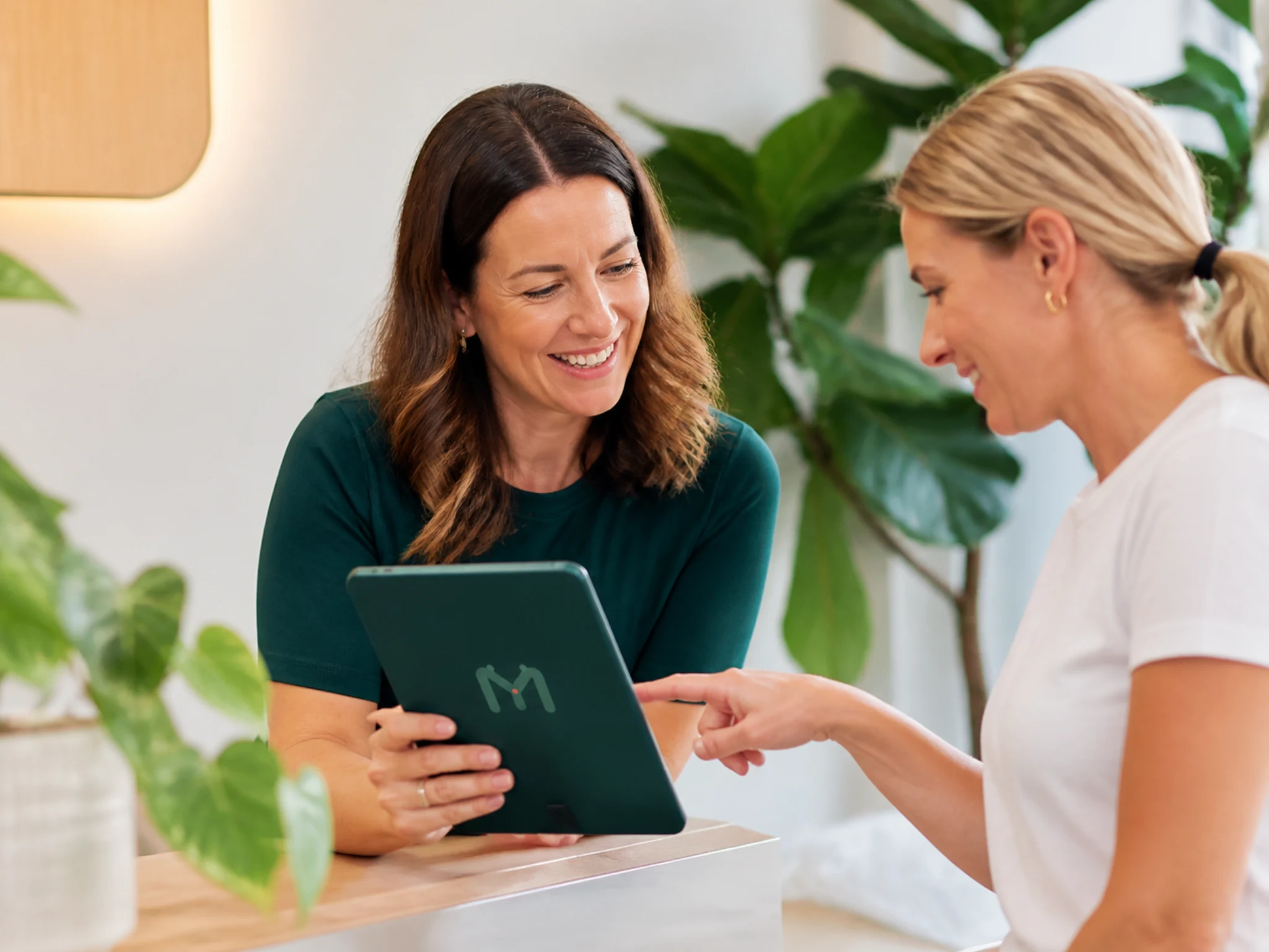 An adult reviewing appointment choices on a tablet with booking support