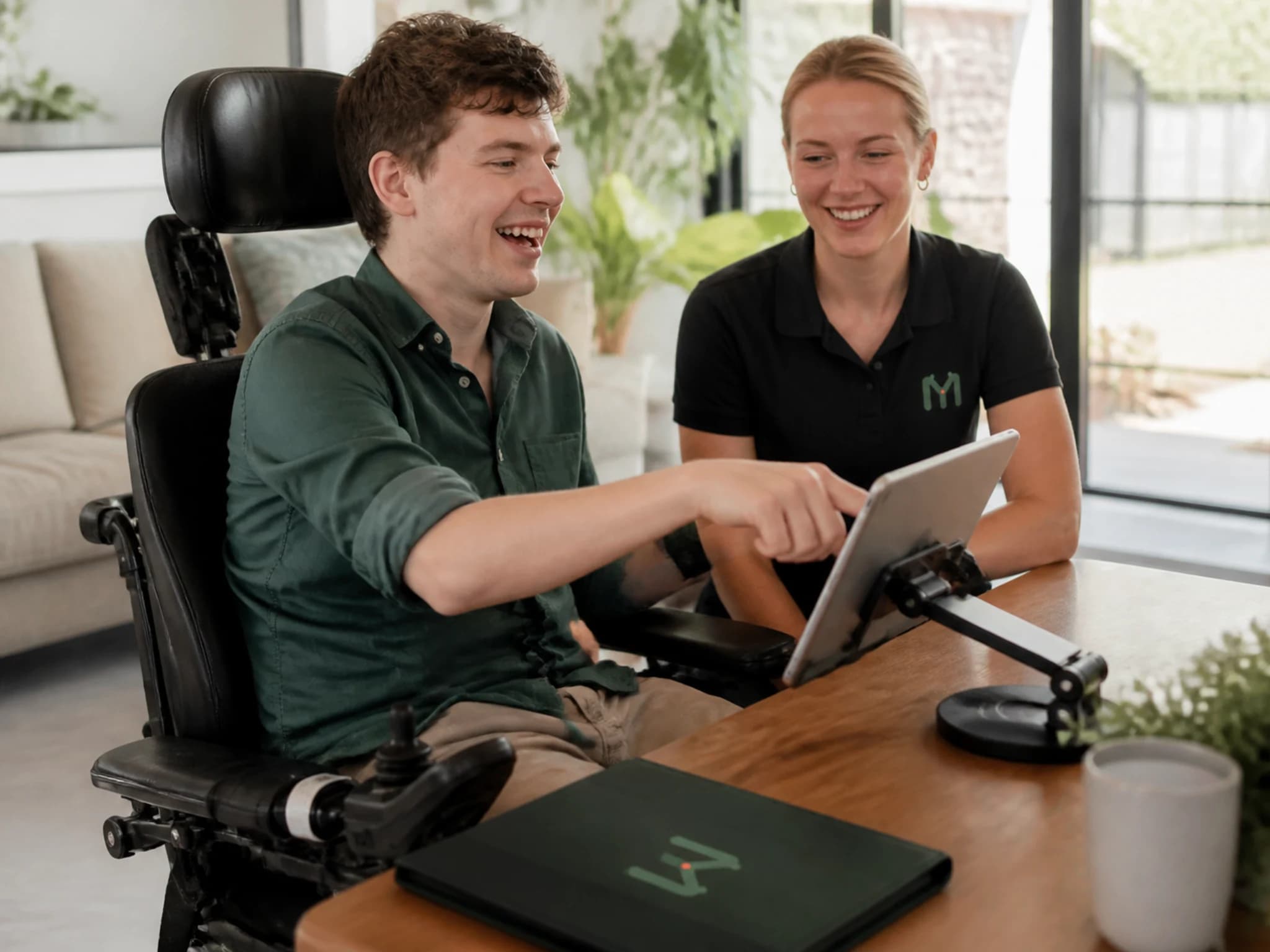 An adult using an adapted home control while a practitioner observes