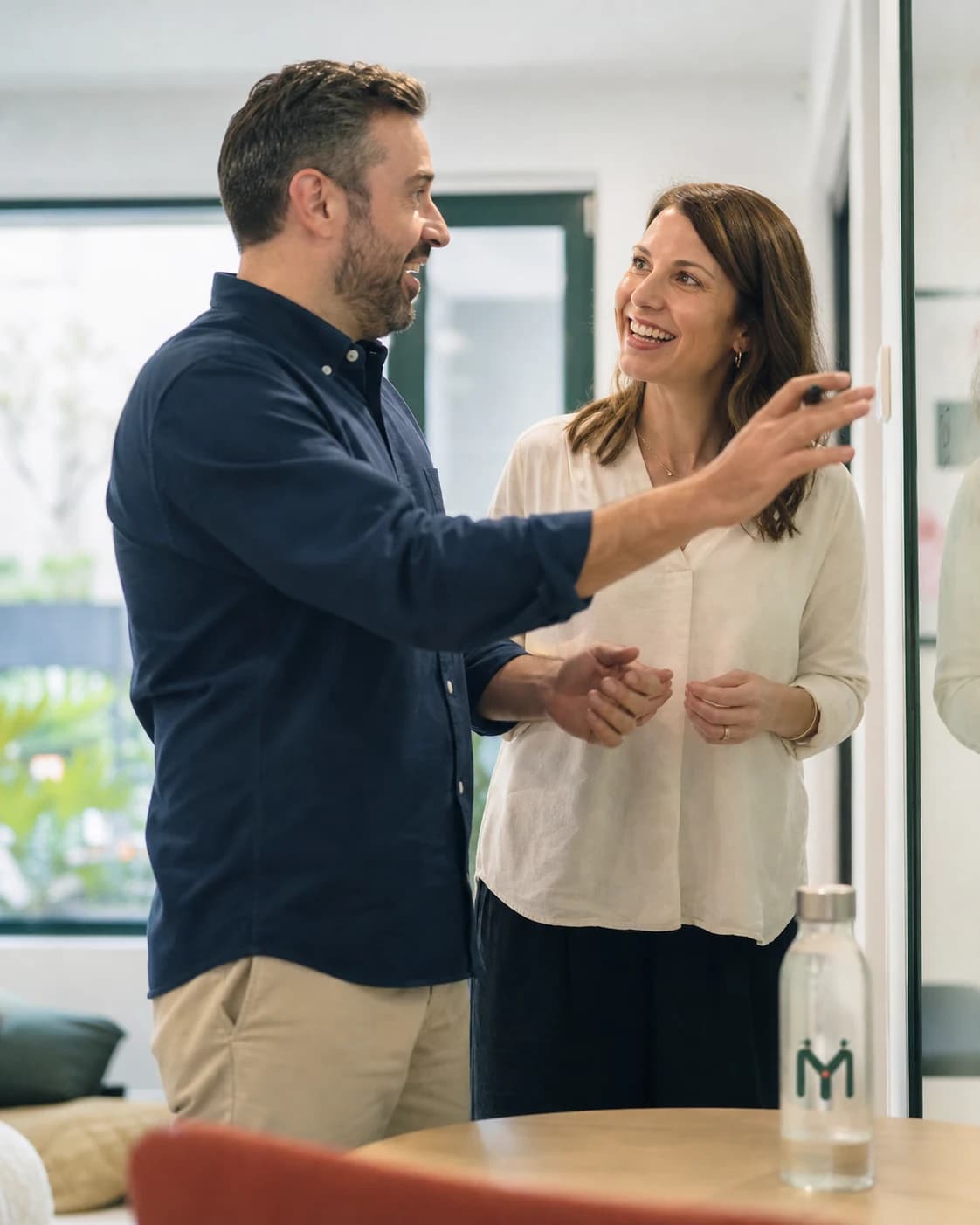 An adult and speech therapist reviewing progress notes at a planning wall