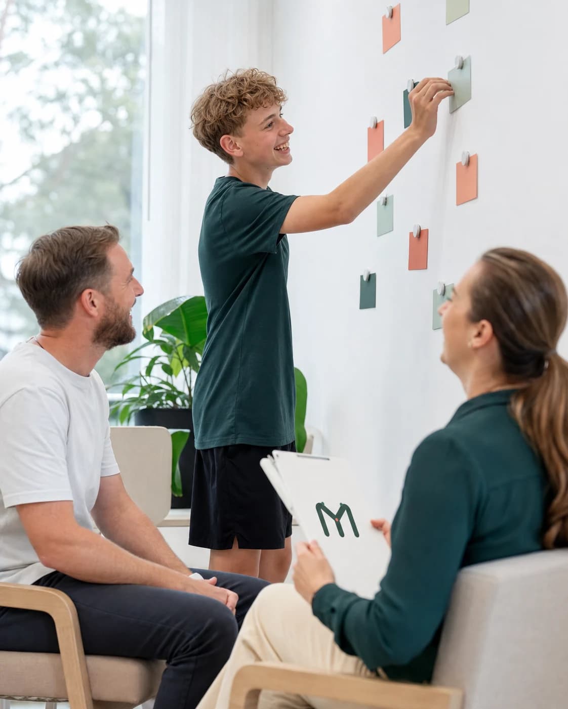 A teenager leading a lively planning session with a parent and therapist